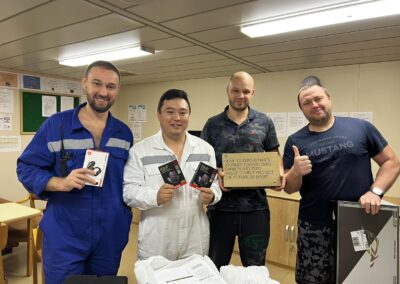 Seafarer Clients of Shore Leave Solutions LLC posing inside the ship each holding items bought by the company in cristi corpus